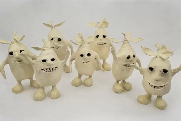 little masking tape figure mangos with leaves, legs, arms, teeth and eyes
