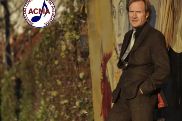 Rupert Wates leaning against a wall, ACMA logo in corner
